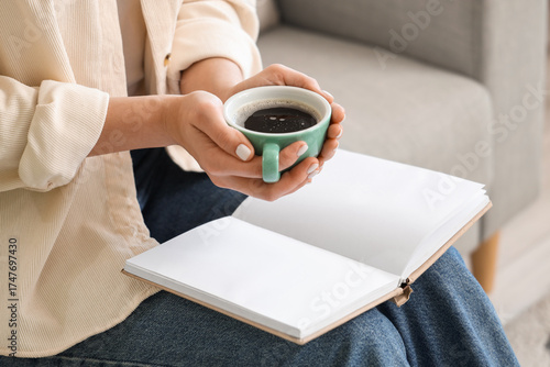 Young woman holding cup of ...