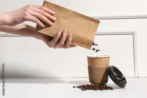 Woman pouring coffee beans ...