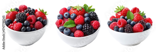 Collection of three white ceramic bowls overflowing with assorted fresh ripe summer berries and green leaves