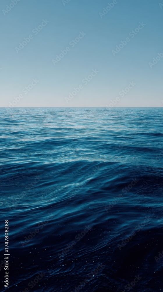 Fototapeta premium Vast Ocean Surface Under Clear Blue Sky with Gentle Waves