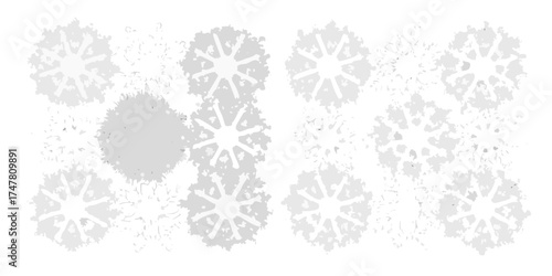 Abstract arrangement of stylized snowflakes in various shades of gray on a white background