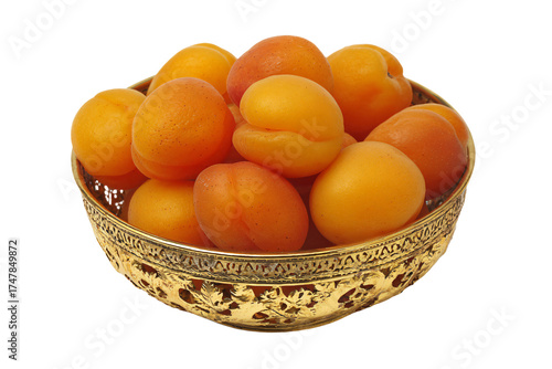 Fresh ripe orange apricots in an ornate golden bowl.