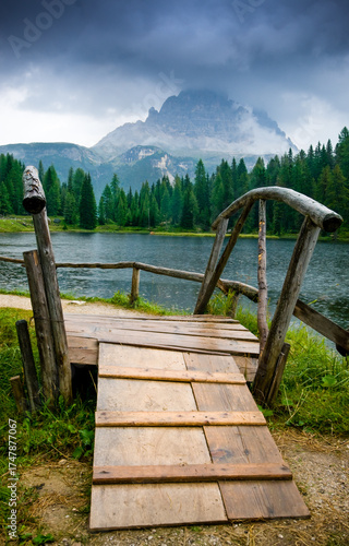 Small wooden bridge at Antorno Lake in a rainy day.  Belluno, Veneto, Italy, Europe.