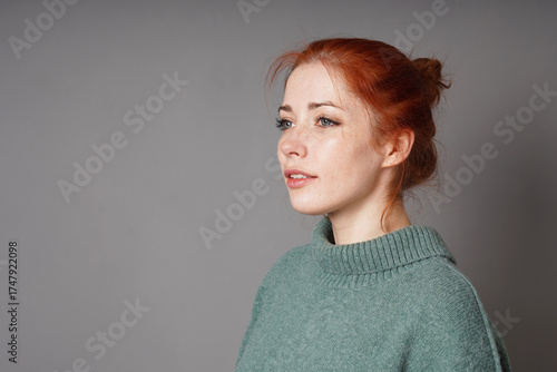 mid adult woman with red hair and freckles looking away