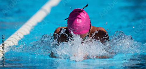 Fotografi Man swims the breaststroke in the swimming pool