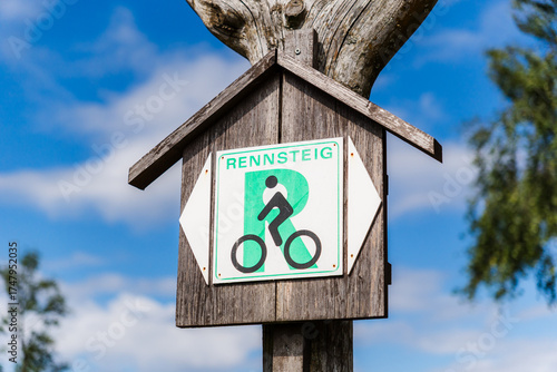 Weathered Wooden Sign for the Rennsteig Cycle Route with Blue Sky