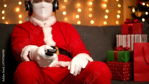 Santa Claus Relaxing on Couch Watching TV with Gifts and Lights.