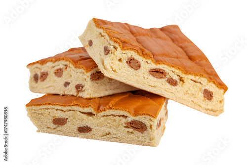 Stacked nougat pieces showcase a textured, golden-brown surface with scattered, embedded inclusions.