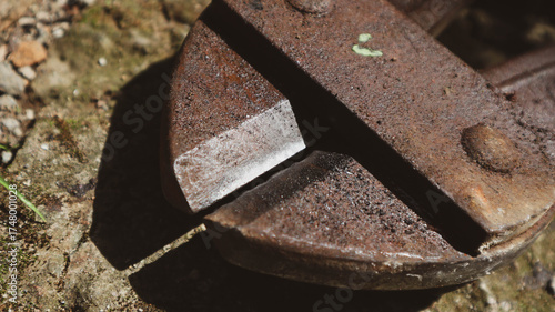 Close-up of rusty bolt cutter on rough surface. Industrial cutting tool ideal for themes of metalwork, construction, maintenance, and tool aging or corrosion.