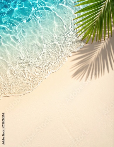 Tropical beach scene, a top-down view of soft sand meeting turquoise water, with a palm leaf shadow