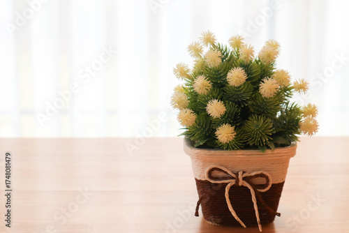 Elegant flower arrangement in a vase placed on a wooden table with soft sunlight and curtain background. Modern minimalist interior design concept showing natural beauty, cozy lifestyle, and home deco