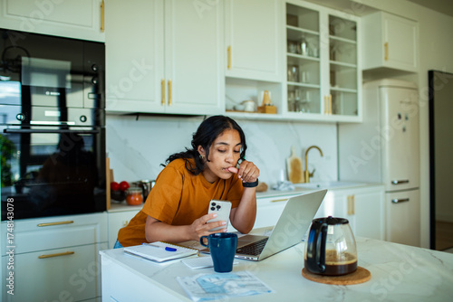 Young woman doing her finances and bills at home