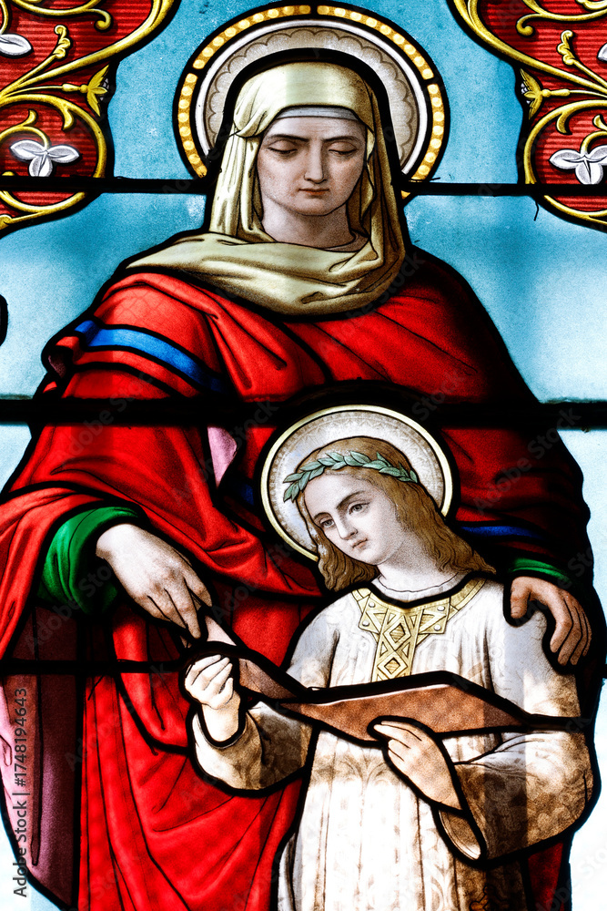 Fototapeta premium Saint Laurent church. Stained glass. The education of Mary by her mother St Anna. Tavernay. France.