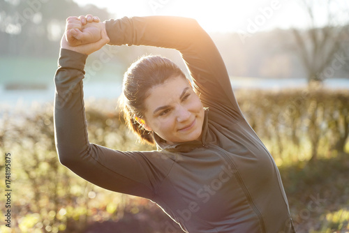 Young sporty woman is stretching after workout, training and running on a beautiful winter morning	
