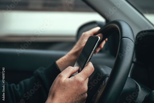 Irresponsible female driver using mobile phone while driving through city streets.
