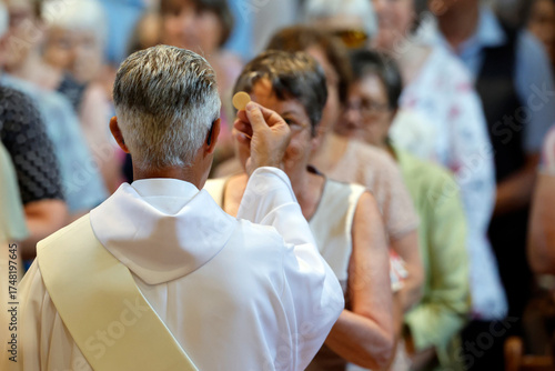 Saint Jacques church.  Deacon giving Holy Communion. Sallanches. France.