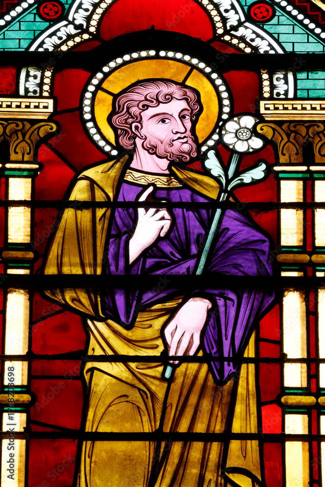 Fototapeta premium Bayeux cathedral. Stained glass. Saint Joseph holding a lily, symbolizing purity, integrity, and his role as the protector of the Holy Family. Bayeux. France.