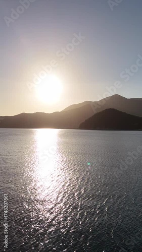 Vertical drone aerial of sunset ocean, horizontal line in Japan, summer travel concept