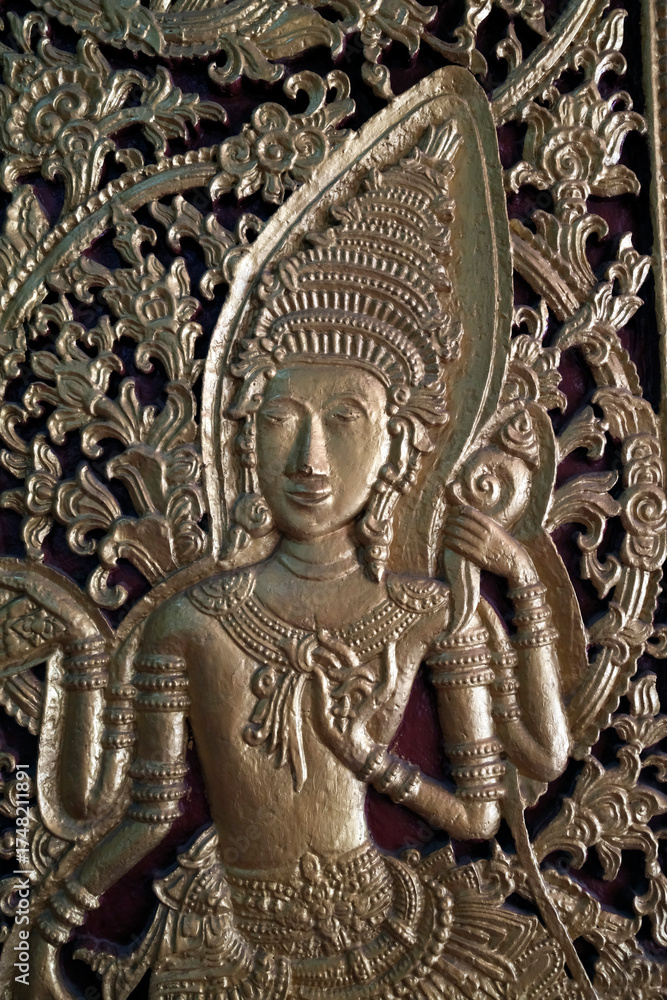 Obraz premium Wat May Souvannapoumaram temple. Door decorated with a celestial dancer. Luang Prabang. Laos.