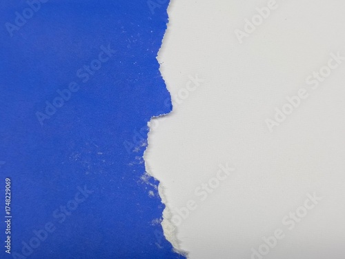 Ripped edge of bright blue crumpled paper, isolated textured with white color background