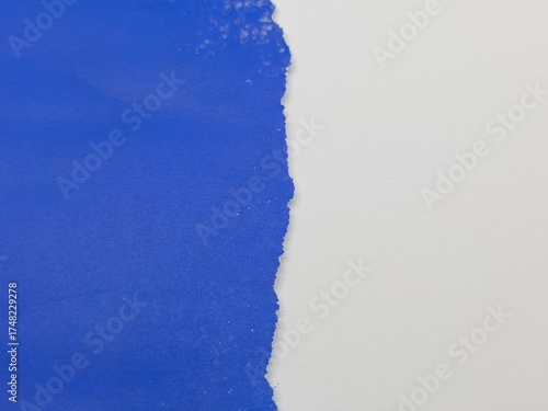 Ripped edge of bright blue crumpled paper, isolated textured with white color background