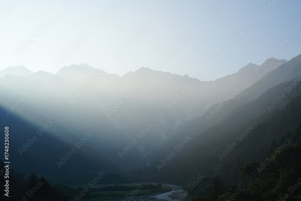 Fototapeta premium Mountain valley dawn with mist over rugged peaks