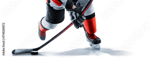 Hockey player close-up. Hockey skates, stick and puck close-up. A hockey player prepares to throw the puck. Focus on the puck. Hockey concept. Isolated