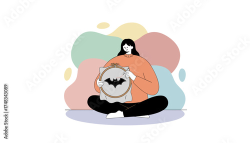 Woman happily embroidering a bat design enjoying a creative hobby and relaxation