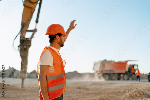 Foto Construction supervisor directing dump truck operations at mining site