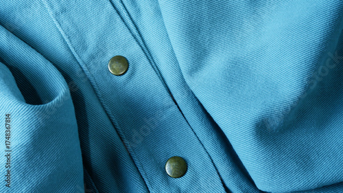 Blue denim fabric texture with metal snap buttons. Close-up buttons jacket. Concept of weave, cotton, clothing, garment, classic, textiles, casual wear fashion for background, wallpaper, content.