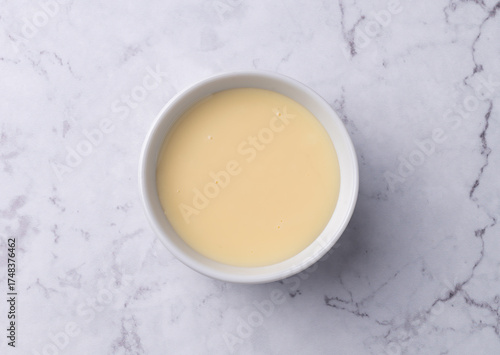 Condensed milk in a bowl over marble table