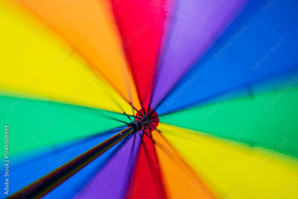 Obraz premium Inside view of spinning rainbow colored umbrella.