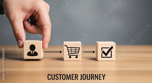 Person Hand Places Wooden Cube With User Icon on Table with Shopping Cart Icon
