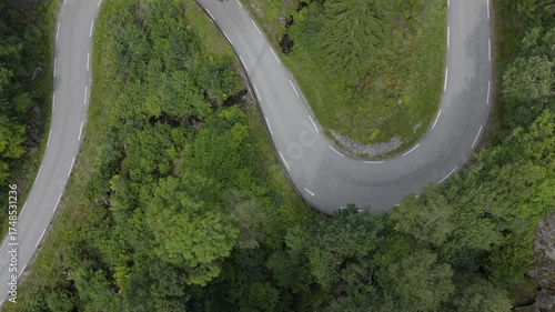 White van driving on mountain hairpin road aerial shot