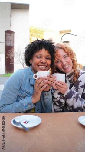Two cheerful women are joyfully sipping their warm beverages, sharing laughter and delightful moments together, embodying friendship and happiness in a delightful atmosphere of connection and joy.