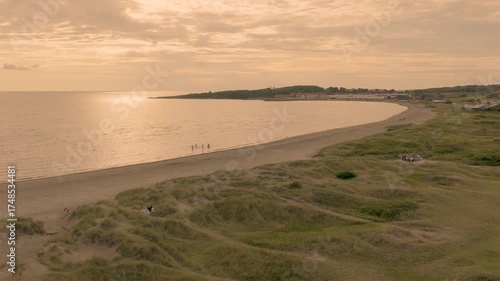 Golden sunset over wide sandy beach shoreline