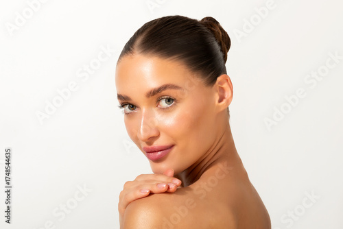 Картината върху платно Portrait of elegant young woman with smooth, clear face skin, posing against white studio background