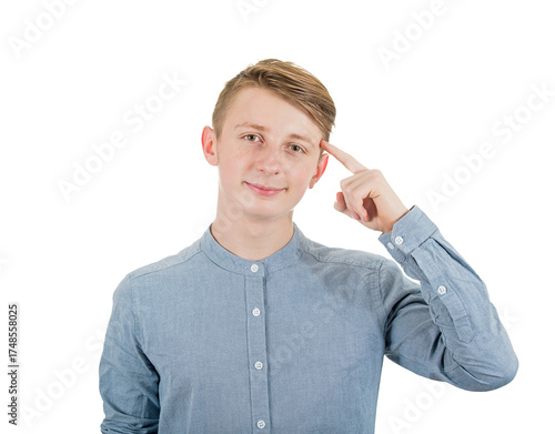 Clever teenage guy portrait pointing forefinger to his temple as looks to camera with confidence. Contented young man adolescent portrait isolated on transparent background
