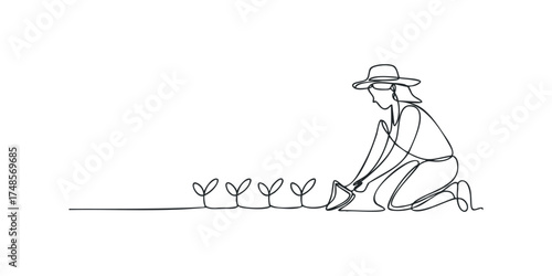 Person watering young plants with watering can