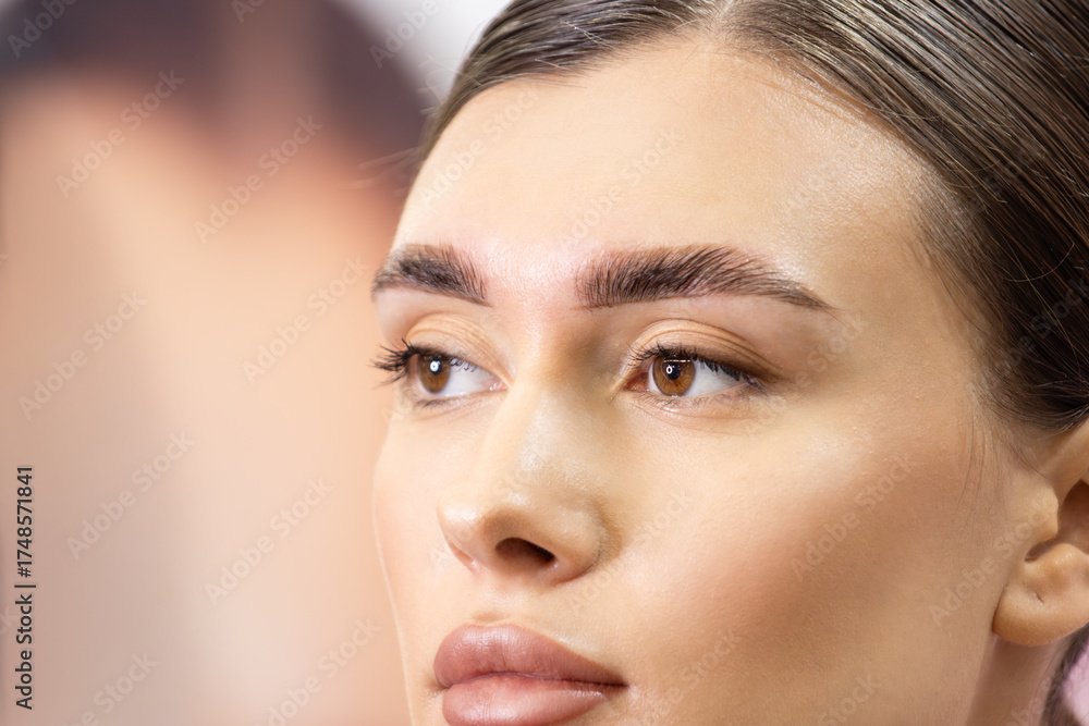 Fototapeta premium Close-up Portrait of a Woman with Perfectly Styled and Laminated Eyebrows. Fresh Look