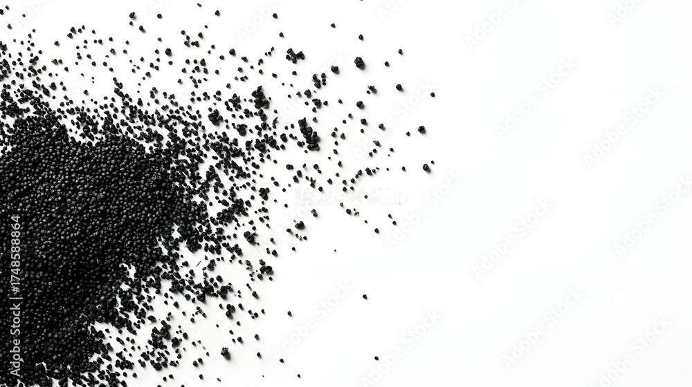 Obraz premium Nigella seeds scattered haphazardly across a white background, creating an organic and natural appearance with their deep black color.