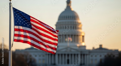 The flag of the United States of America waving in the wind with the U.S. Capitol Building blurred in the background during a golden sunset, symbolizing American government and patriotism.

