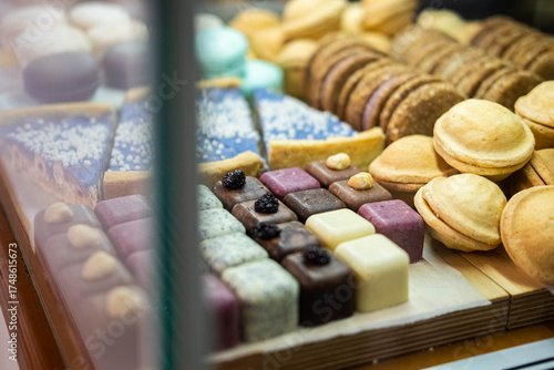 Schilderij op canvas A variety of biscuits, cookies, and petit fours are neatly displayed in a glass bakery showcase