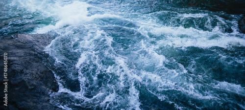 Εκτύπωση καμβά Water crashing against rocks, white water rapids, cold blue river scene