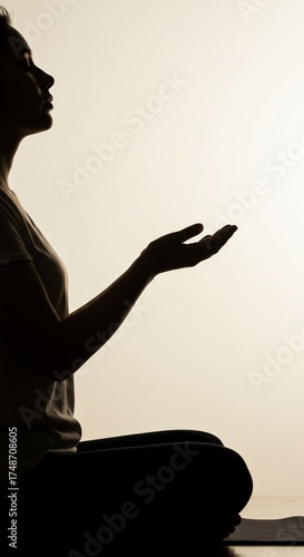 Inner Serenity: A woman sits serenely, her silhouette against a soft light, embodying the tranquility of meditation. Her hands are gently open, inviting a sense of peace and stillness. 