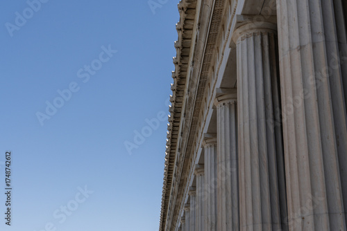 Close-up view of classical marble columns in the Ancient Agora of Athens, Greece. Captures the elegance and symmetry of ancient Greek architecture under a clear blue sky.