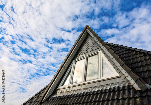 Foto House roof dormer window contrasting blue sky