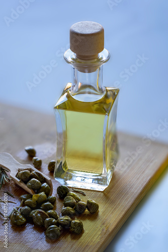 A small bottle of olive oil and a pile of  capers.