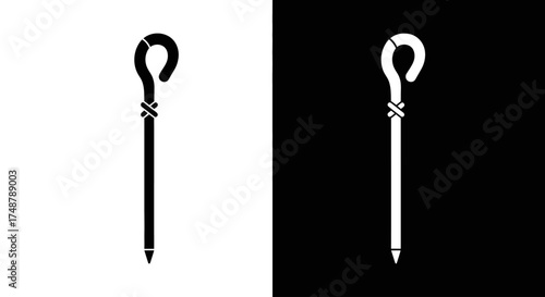 A minimalist black and white icon of a shepherd's crook or staff, featuring a looped handle and pointed end.