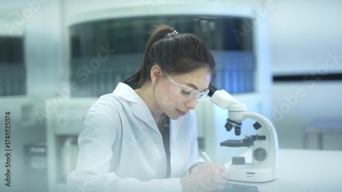 A medical technologist in a hospital laboratory examines a patient's biological sample under a microscope, carefully documenting the cellular morphology for a precise clinical diagnosis.